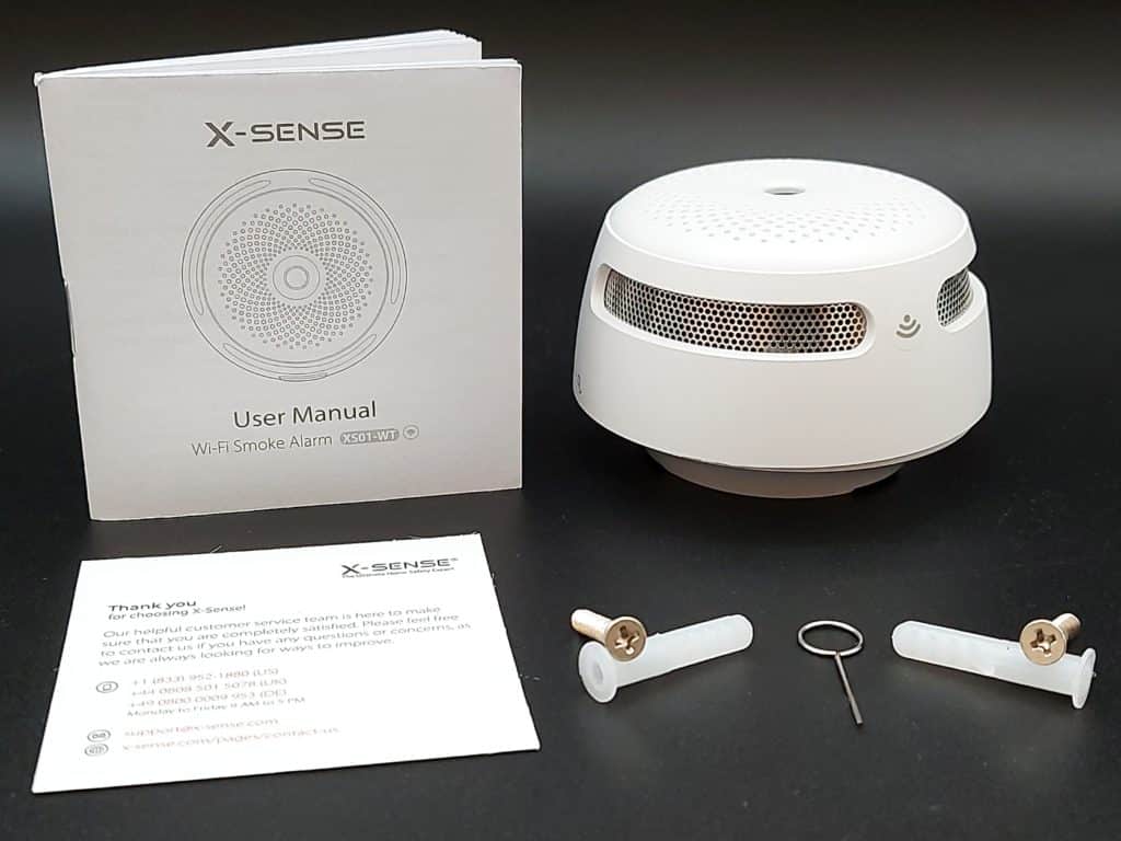 Détecteur de fumée connecté X-Sense avec ses accessoires de visserie et manuel d'utilisation