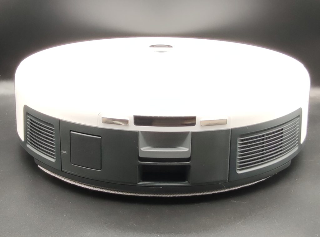 l'arrière du robot tout sombre comporte le bac à poussières et au dessus les contacteurs pour le rechargement du robot